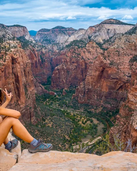 Hiker sitting at Angels Landing overlook above Zion Canyon