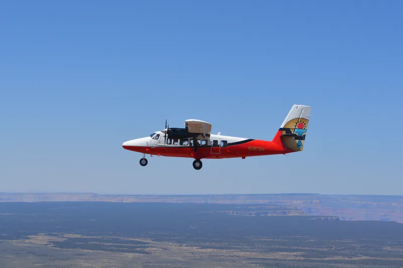 Red and white Papillon scenic flight plane in the air above the Colorado Plateau