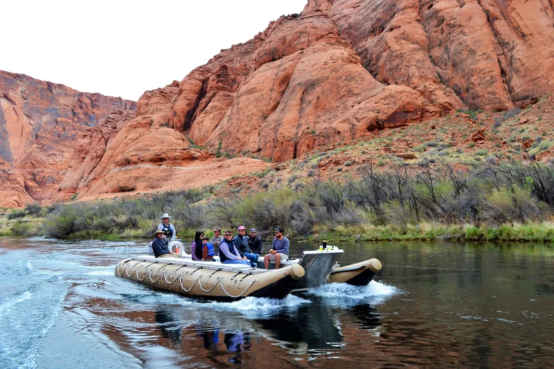 Guided raft on the Colorado River below Horseshoe Bend canyon walls