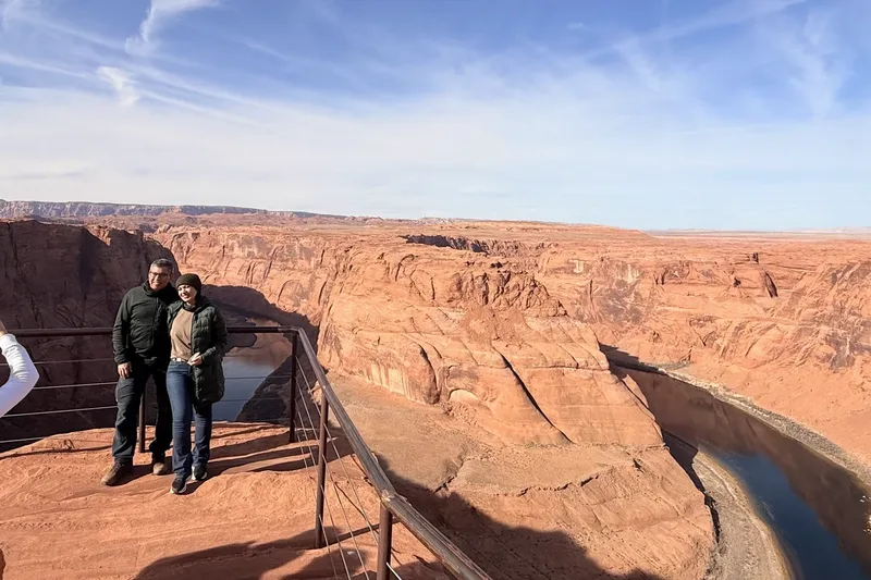 Visitors at Horseshoe Bend overlook with the Colorado River bend far below