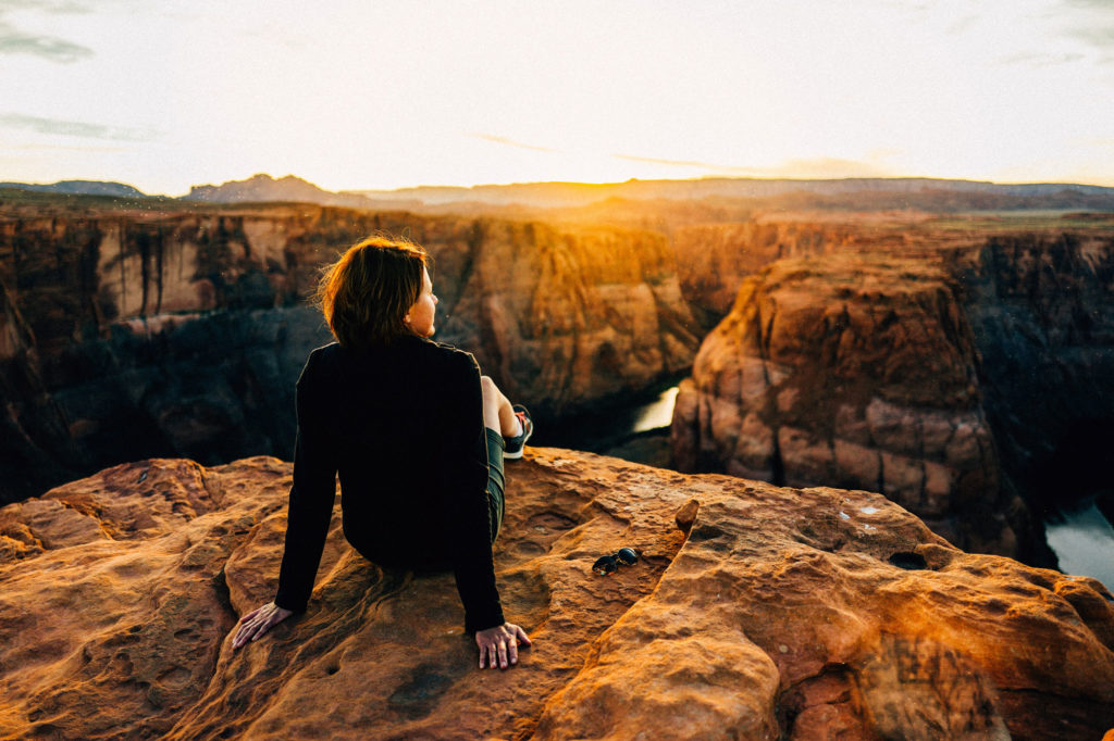 Hiker sitting and looking across Horseshoe Bend